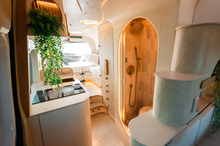 Flow's galley, arched tiled shower, and rear dinette with warm integrated lighting
