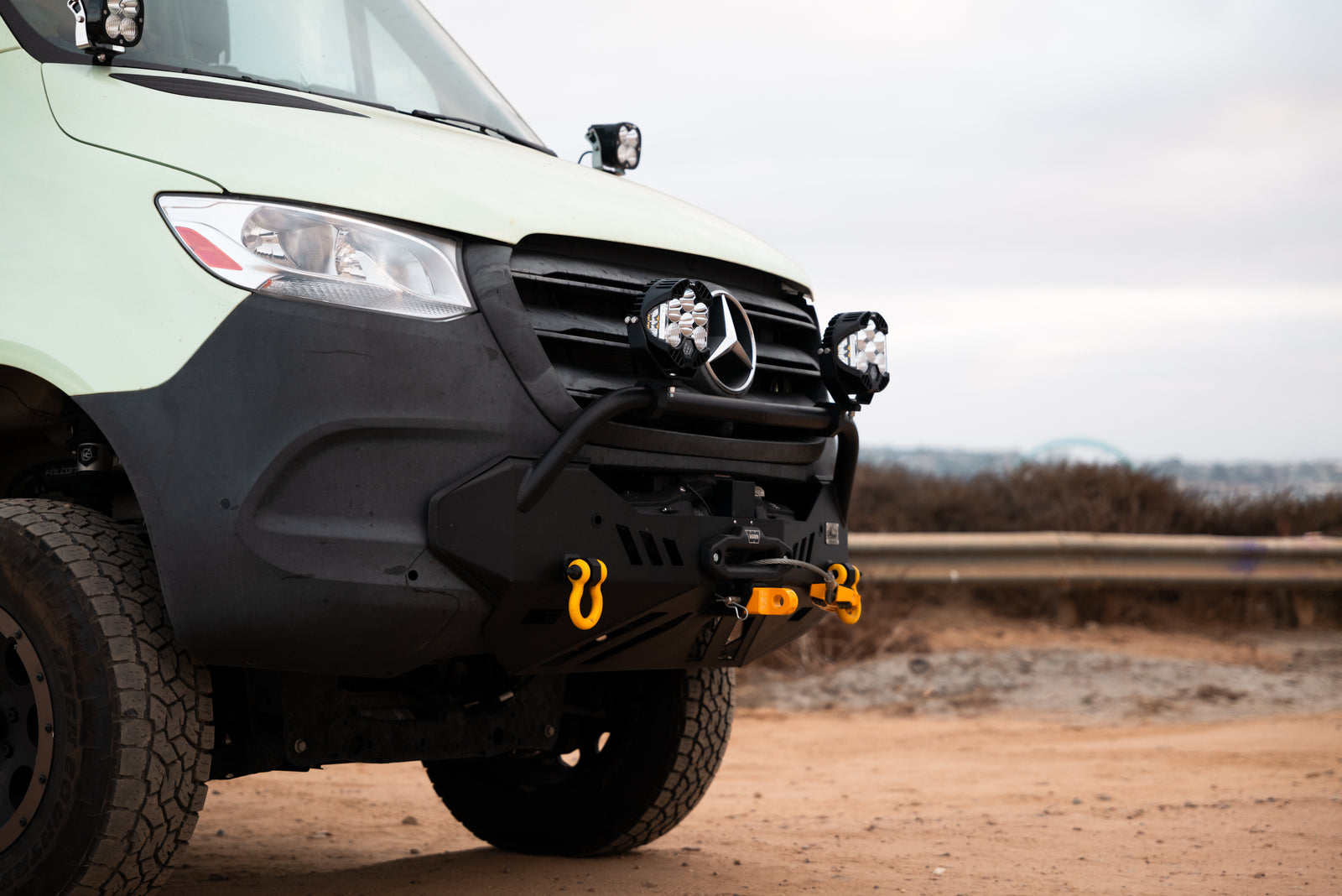 Close view of Flow's front bumper, winch, auxiliary lights, and yellow recovery points