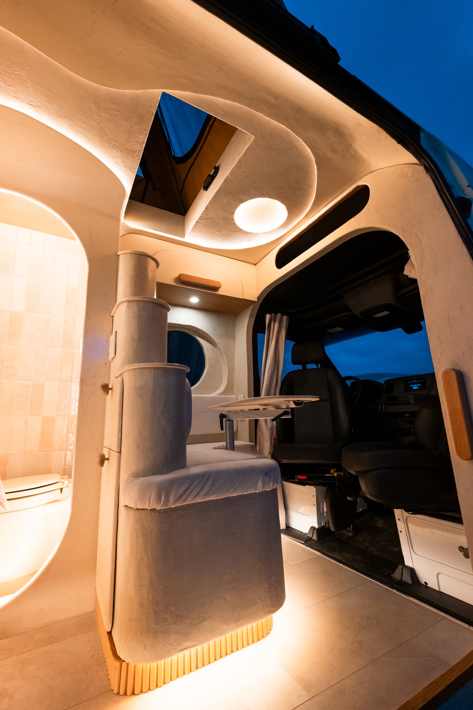 Flow's front dinette, wet bath, and pop-top opening illuminated at blue hour