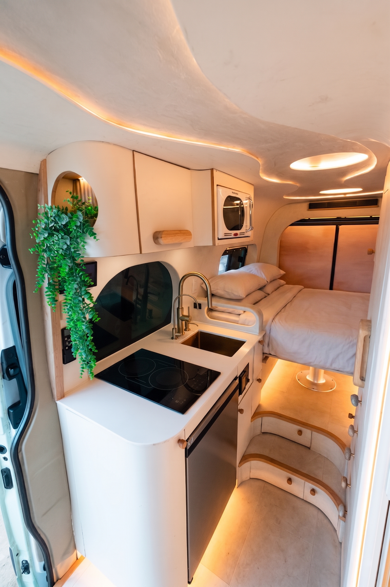 Flow's galley and made-up rear bed, with curved plaster ceilings and warm integrated lighting