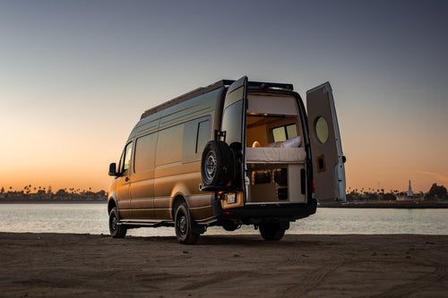 Luna at golden hour on the beach with side door open.
