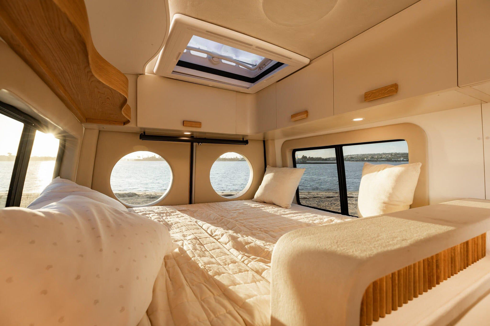Luna interior — bedroom and galley through portholes overlooking water.