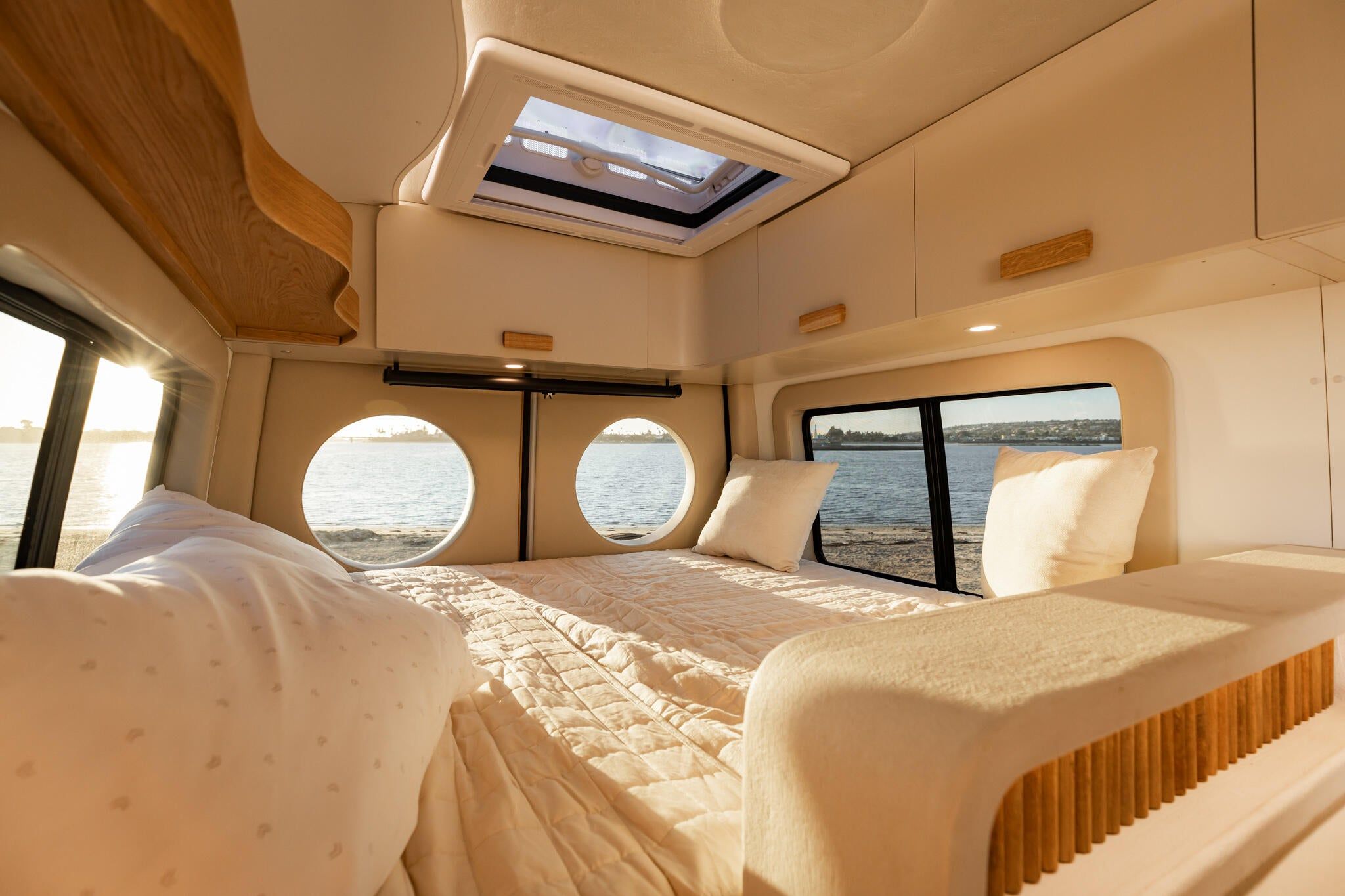 Luna interior — bedroom and galley through portholes overlooking water.